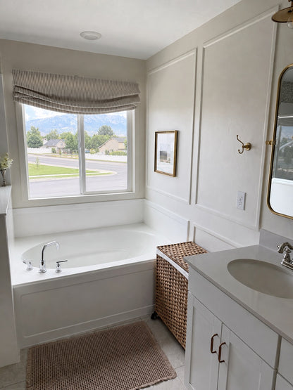 Custom cordless relaxed roman shades with soft curved bottom in modern living room setting