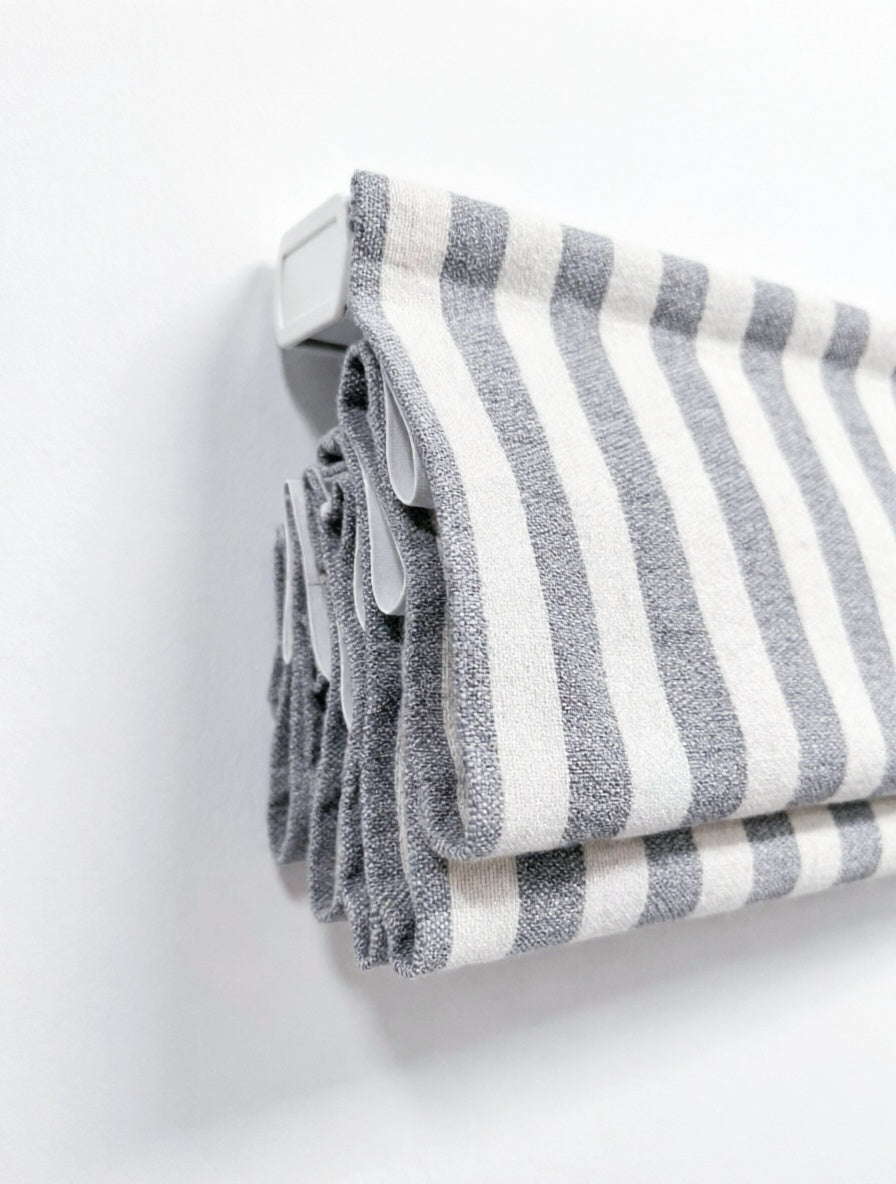 Custom hobbled roman shades in gray and white striped fabric with textured cascading folds and a waterfall top
