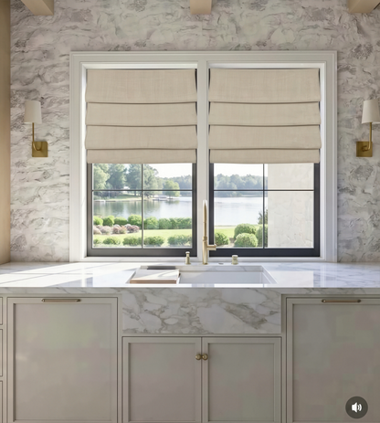 custom hobbled roman shades in beige linen-blend fabric with soft, layered horizontal folds across two windows