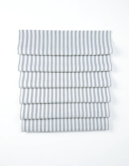 custom hobbled roman shades in white fabric with narrow gray vertical stripes and soft cascading folds