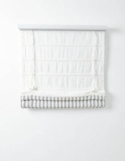 Custom hobbled roman shades in white fabric with a gray and white striped bottom band and soft layered folds