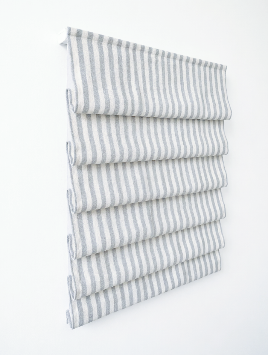 custom hobbled roman shades in white linen blend with narrow gray vertical stripes and soft cascading folds
