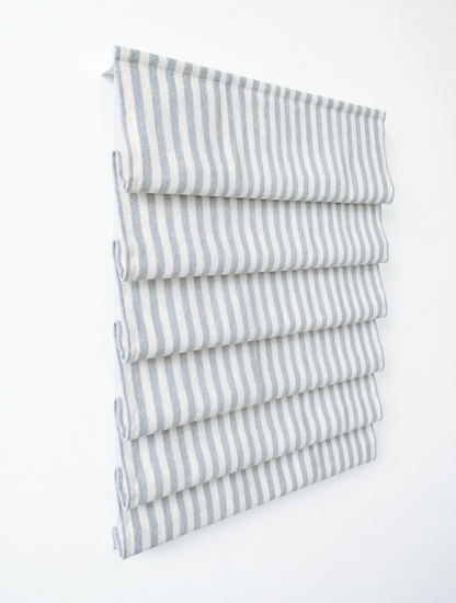custom hobbled roman shades in white linen blend with narrow gray vertical stripes and soft cascading folds