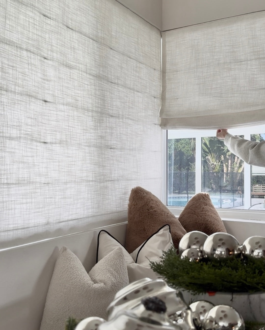 Cordless custom roman shade in natural linen with soft folds for light-filtering and blackout window treatment