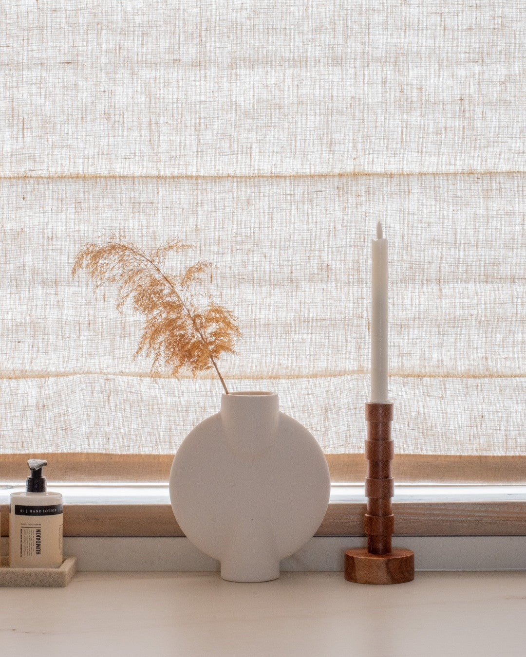 Custom cordless roman shade in natural linen for soft, elegant light-filtering and blackout window treatment