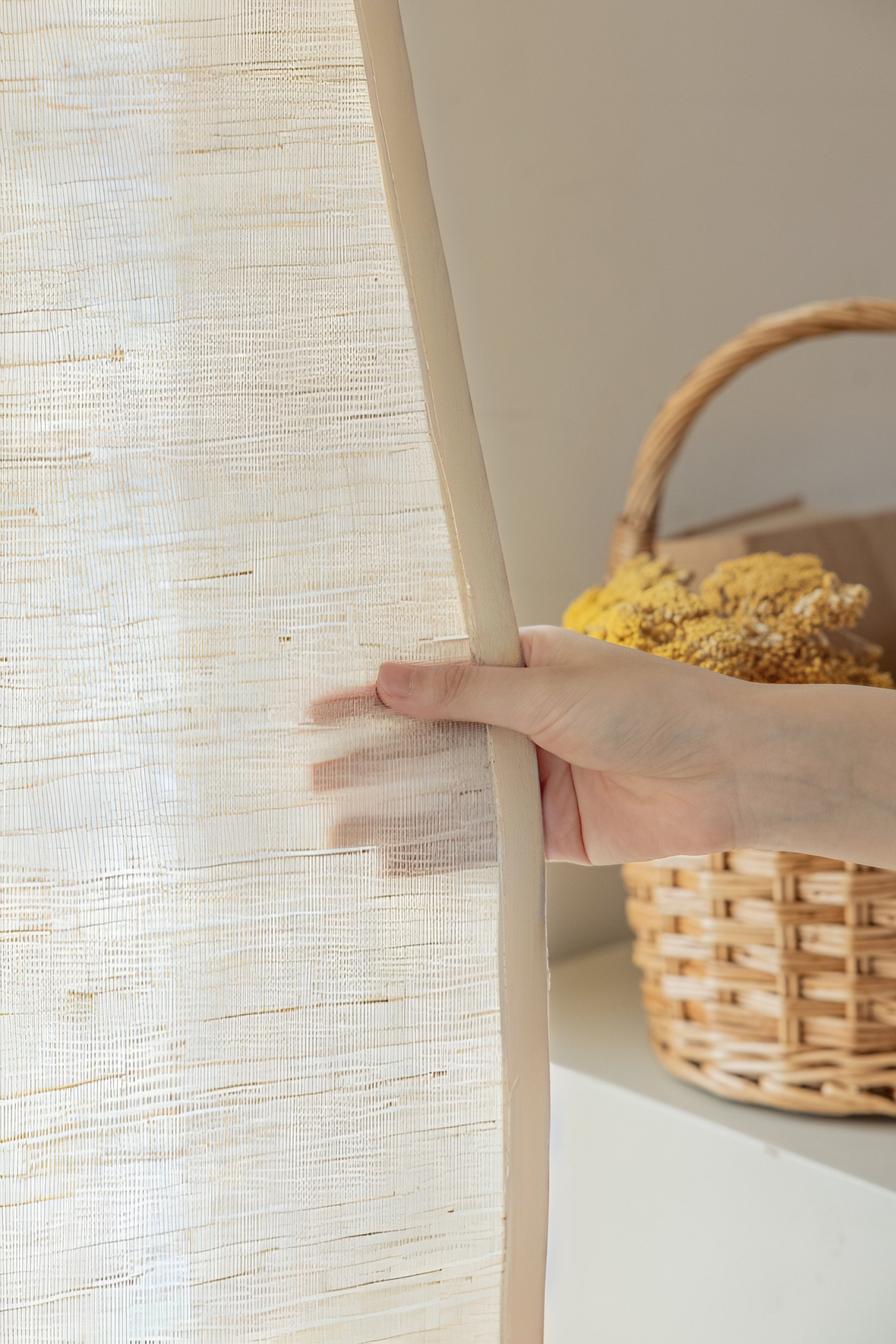Natural coconut white ramie bamboo window shades with delicate woven texture, shown being gently held to display softness and breathability.