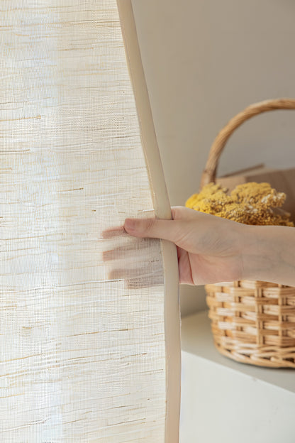 Natural coconut white ramie bamboo window shades with delicate woven texture, shown being gently held to display softness and breathability.