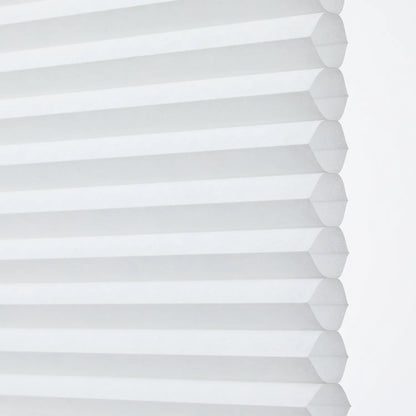 Close-up of white honeycomb blind shade with hexagonal cells, providing superior light filtering and insulation, suitable for bathroom settings
