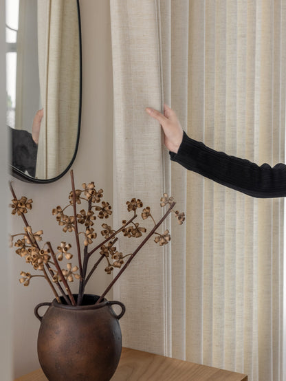 Elegant luxury French linen curtains in soft natural colors hanging in a bright airy room
