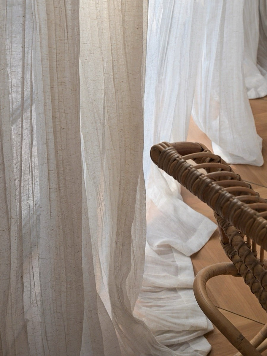 Gauze curtains in a sheer beige linen blend, with a fine grainy texture and relaxed, irregular crinkles.