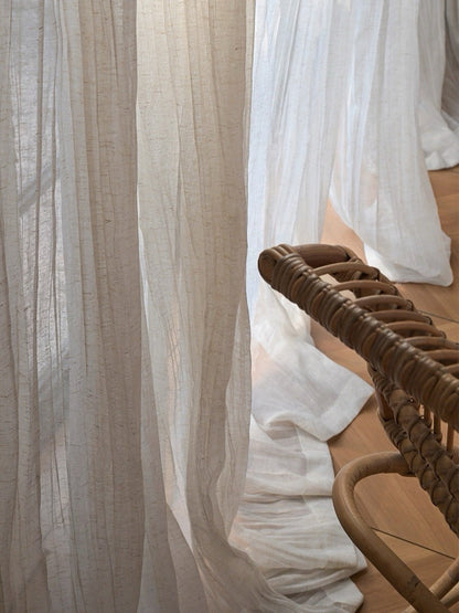 Gauze curtains in a sheer beige linen blend, with a fine grainy texture and relaxed, irregular crinkles.