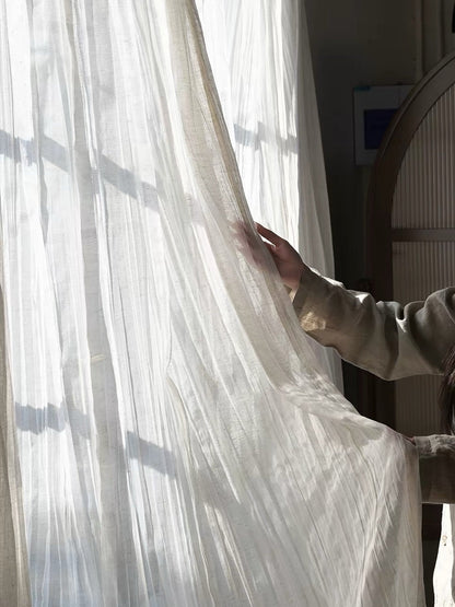 Gauze curtains in ivory linen-blend fabric, sheer with fine texture and relaxed crinkled waves for a soft drape.