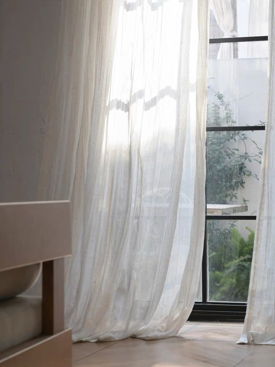 Gauze curtains in sheer ivory linen-blend fabric with fine texture and relaxed, flowing crinkles.