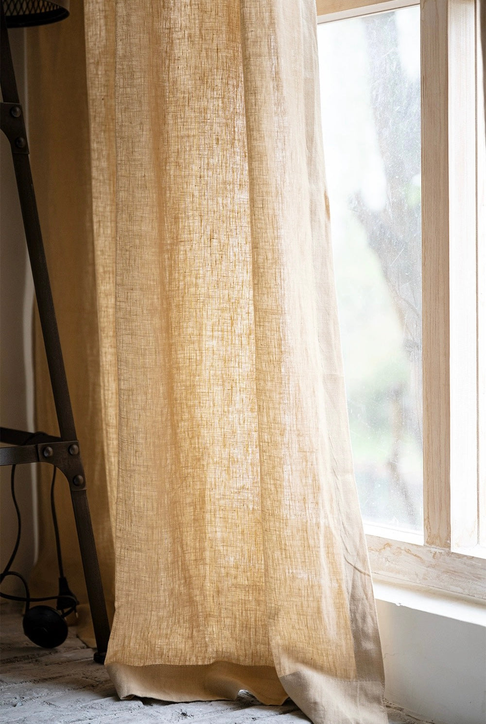 Mustard yellow linen curtains draped by sunlit window, showcasing natural texture and warm soft yellow color