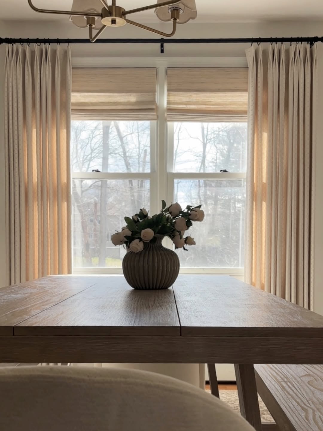 Natural Ramie Bamboo Roman Shades in beige woven natural fibers, featuring softly folded panels above a dining table