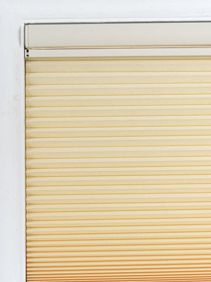 No drill honeycomb shades in a cream fabric with horizontal pleats and a cordless, tool-free design