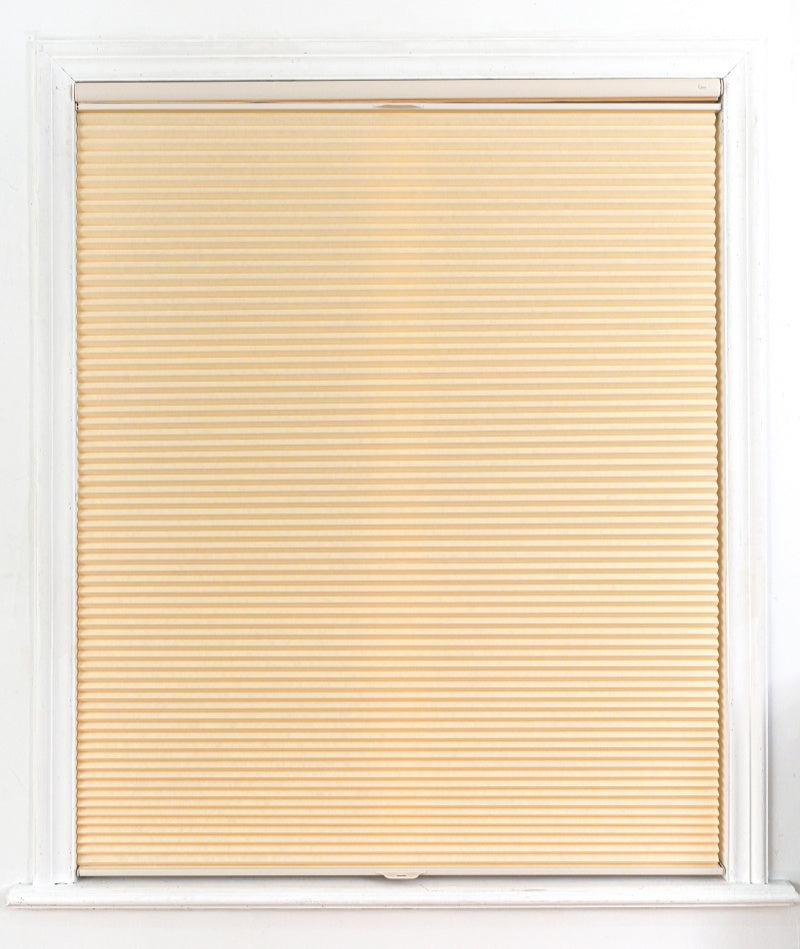 No drill honeycomb shades in warm beige fabric, featuring a cordless pleated design for windows