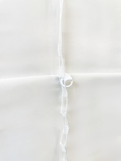 Patterned Roman Shades in white linen with horizontal seams and a visible white cordless lift cord mechanism along the side