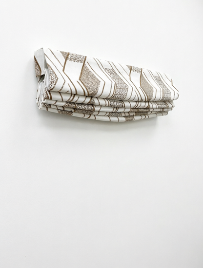 Patterned Roman Shades in cream linen with raised brown geometric embroidery and crisp flat-fold construction