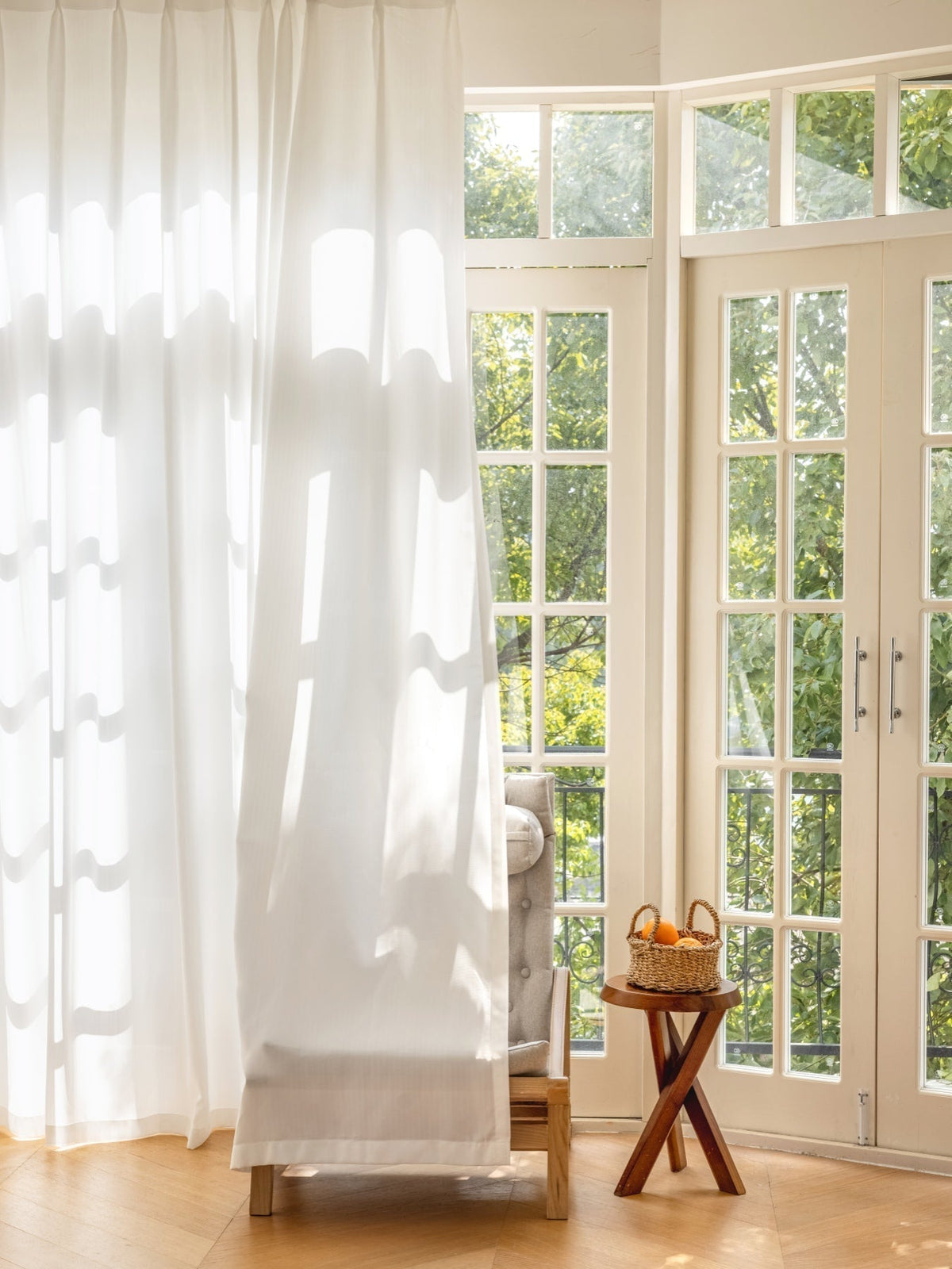 White sheer curtain blocking view from outside while allowing natural light inside a bright room
