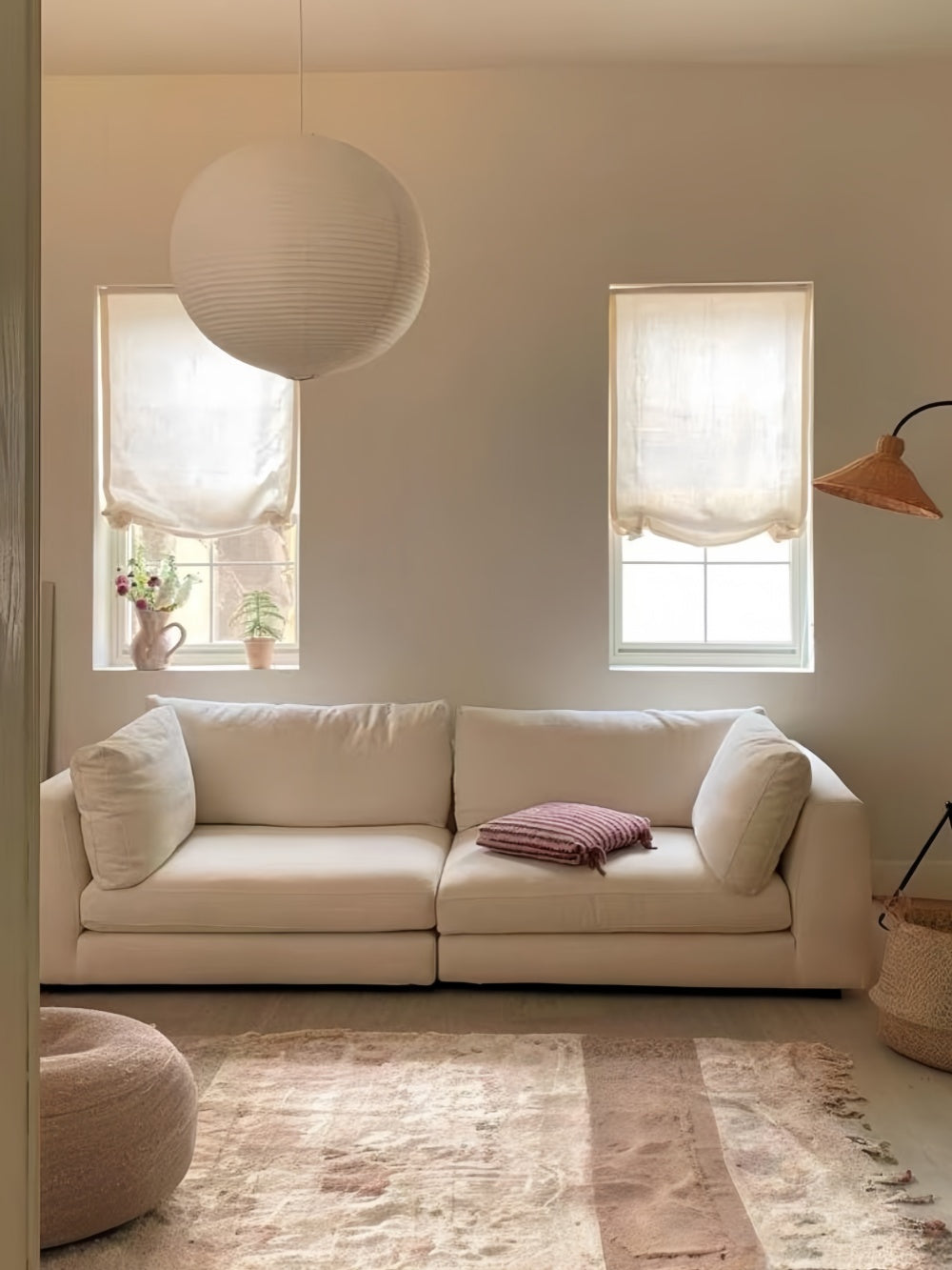 Light-filtering relaxed Roman shades with soft waves in a cozy living room setting.