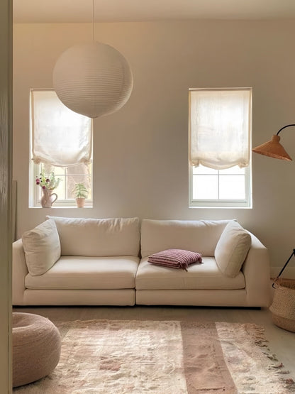 Light-filtering relaxed Roman shades with soft waves in a cozy living room setting.