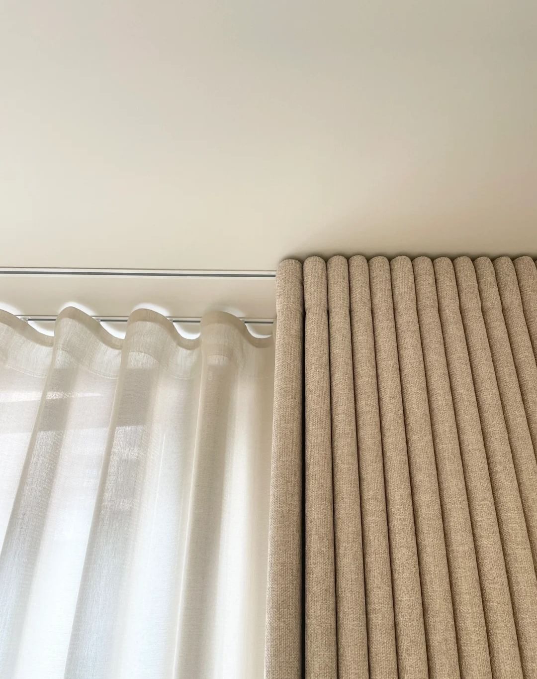Floor-to-ceiling ripple fold curtains styled in a contemporary living space