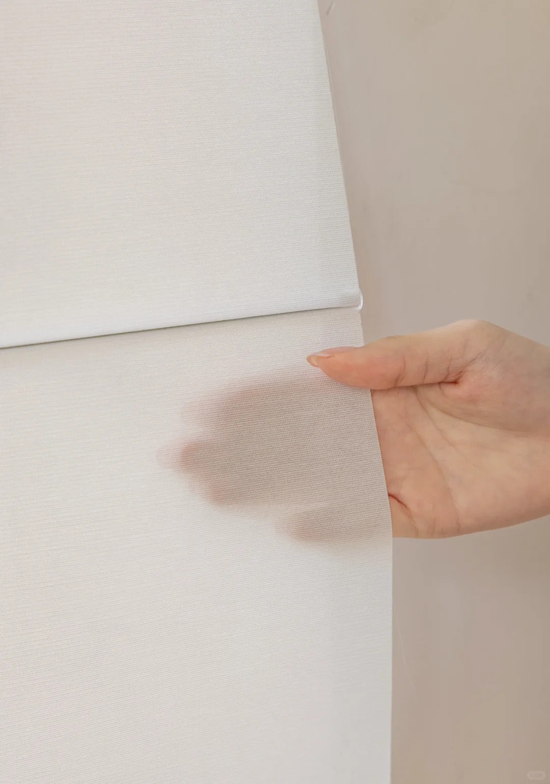 Close-up of semi-blackout white Roman shades that filter light.