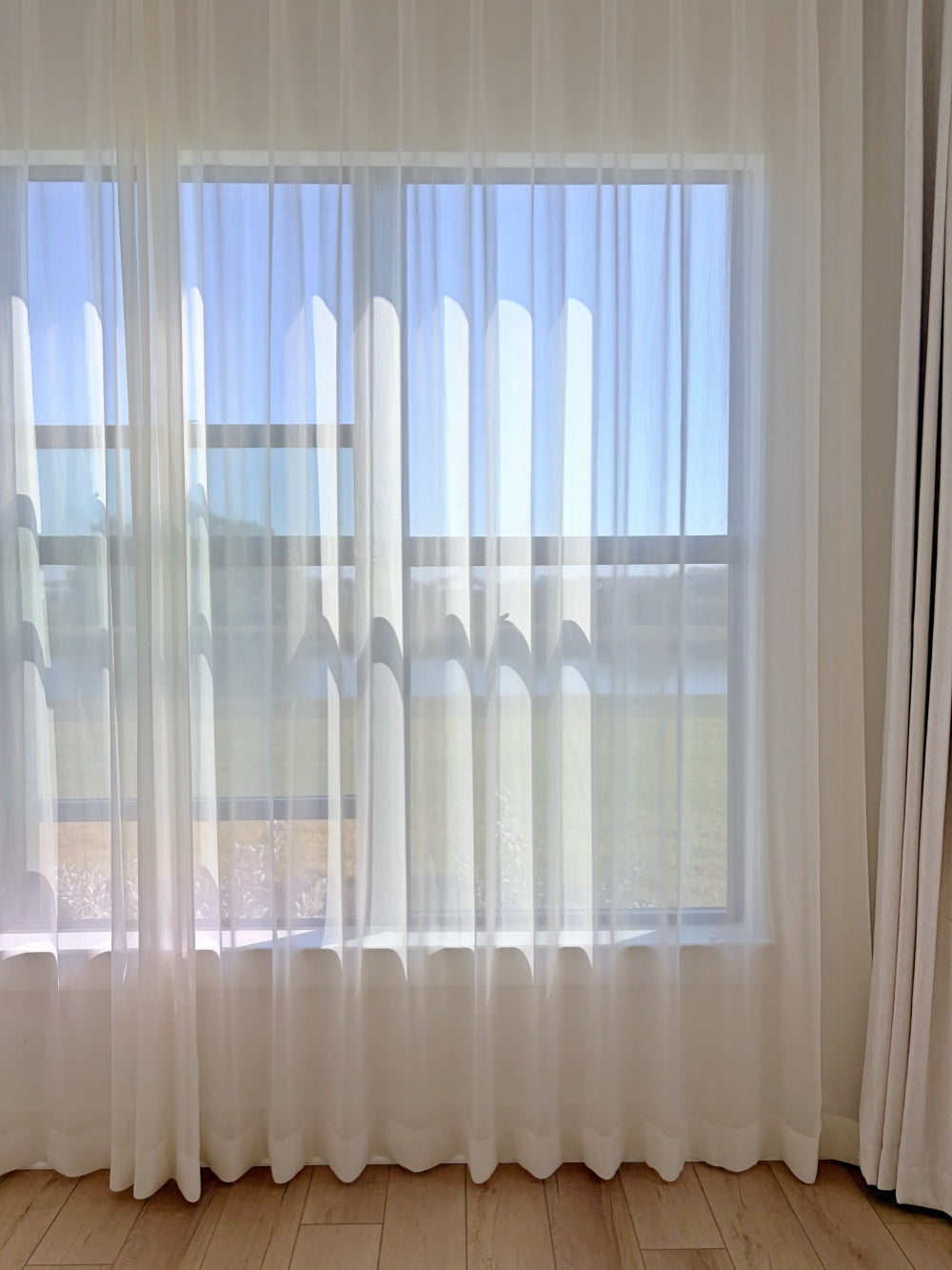 Luxury sheer curtains with shimmering threads glowing in sunroom light