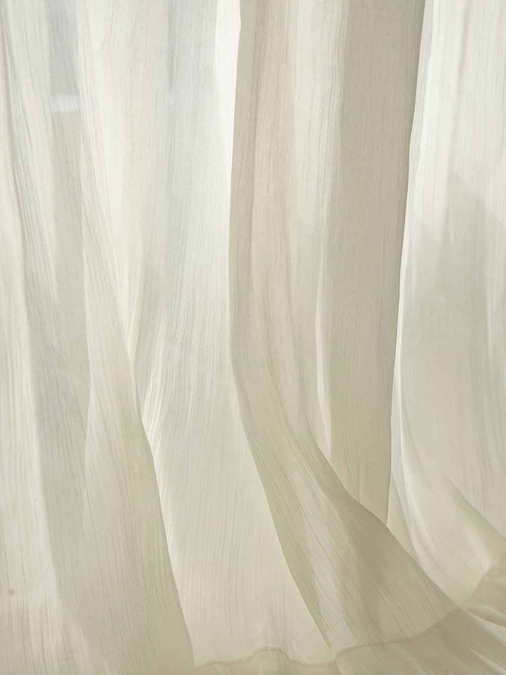 Luxury sheer curtains with shimmering threads glowing in sunroom light