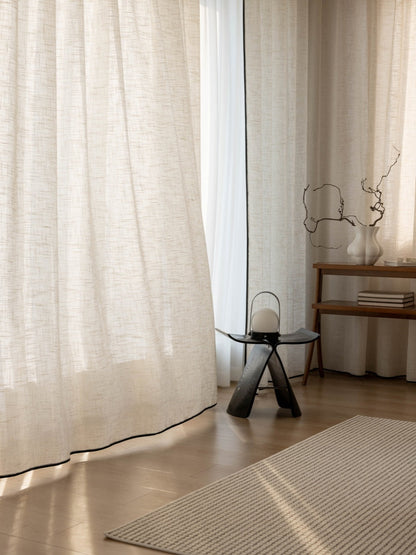 Sheer linen curtains softening sunlight in elegant living room window