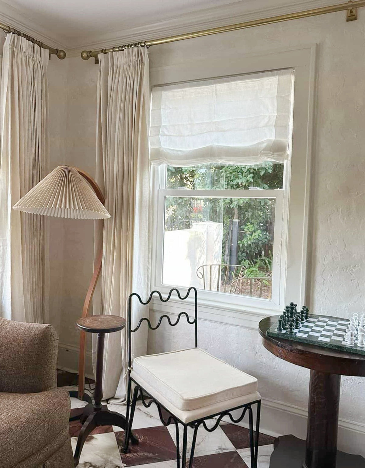 sheer Roman Shade in natural ivory linen, featuring soft horizontal folds that filter daylight