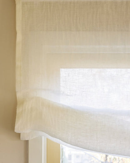 Soft sheer Roman shade in 100% pure linen with gentle folds filtering light and providing privacy