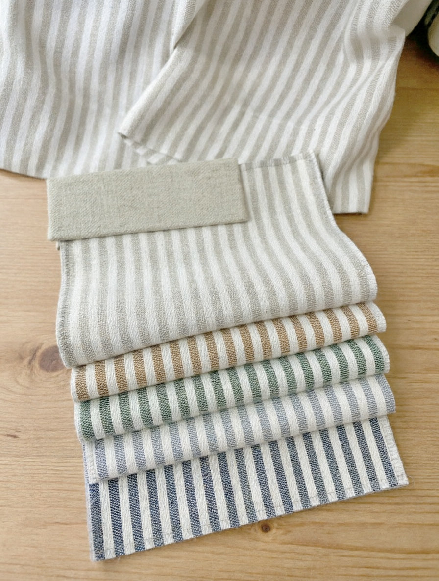 Striped Roman Shades in textured fabric swatches with vertical stripes in ivory, beige, sage, pale blue and navy