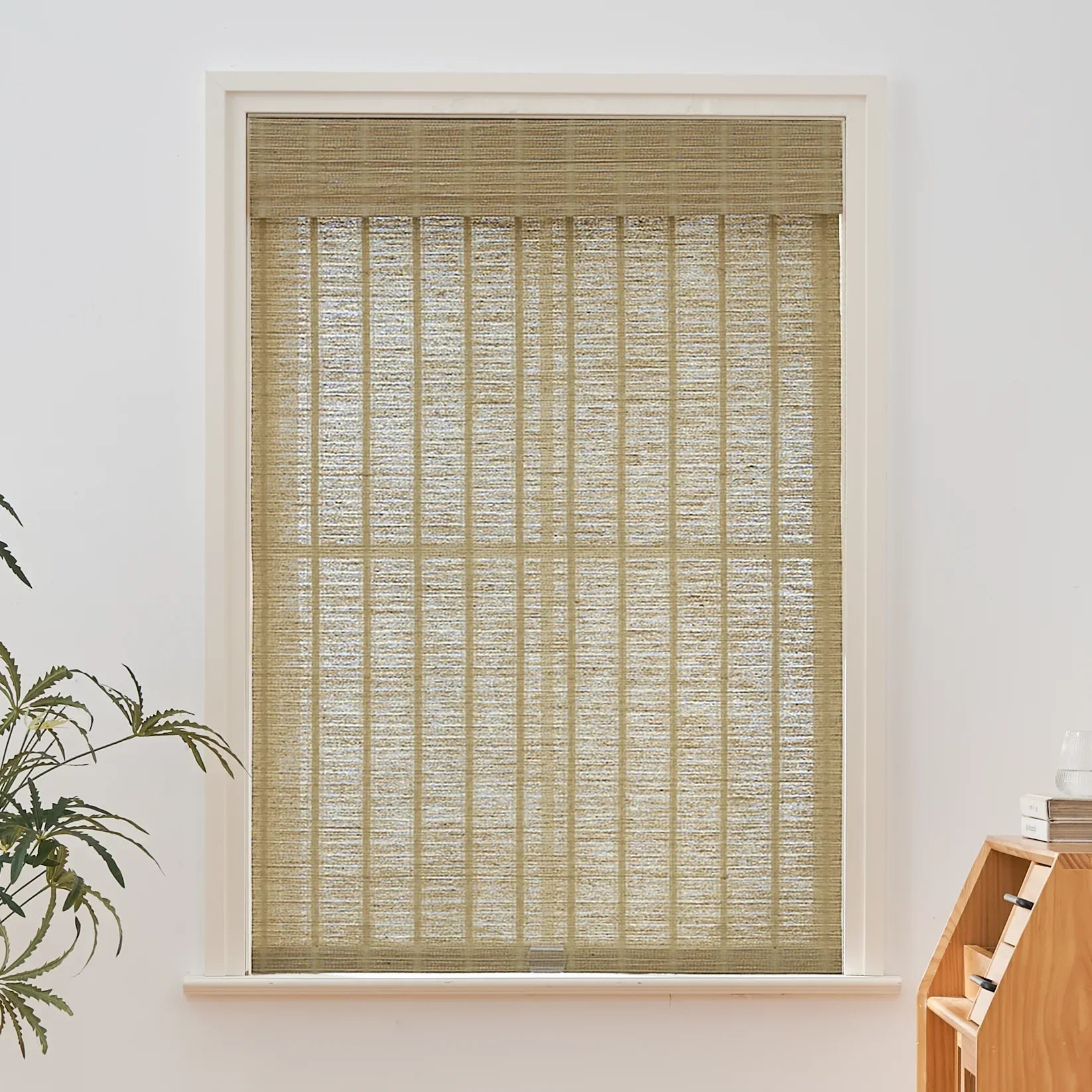 Natural jute bamboo outdoor shades in oak tone installed in window.