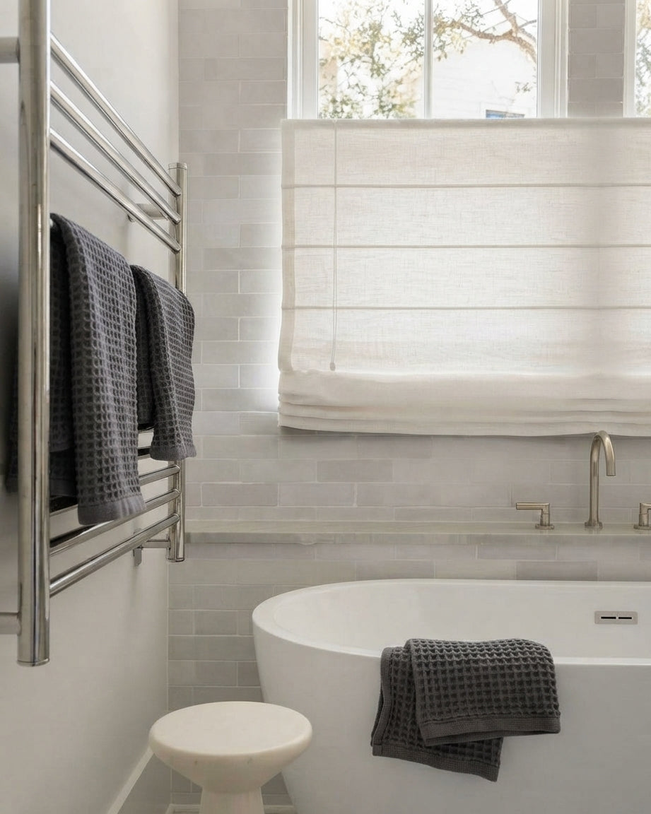Top Down Bottom Up Roman Shades in natural linen with layered folds and light-filtering fabric over a bathtub window