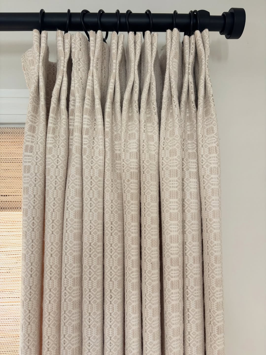 Vintage curtains in a light beige woven fabric with an intricate repeating medallion pattern and heavyweight pleated drape