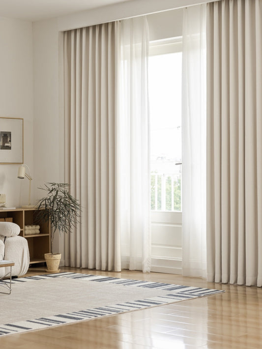Heavyweight linen blackout curtains in warm off-white for bedroom, showing full drape and natural texture.