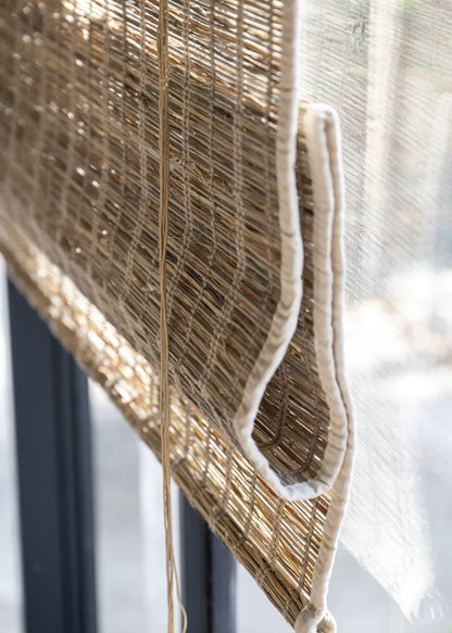 Woven Roman Shades in warm cinnamon jute with a natural woven texture and visible braided edge detail